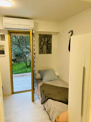 a bedroom with a bed and a sliding glass door at 3 pièces terrasse, jardin in Cannes