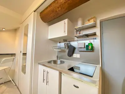a small kitchen with white cabinets and a sink at Mini Studio - Le Chabaud - Cannes centre in Cannes