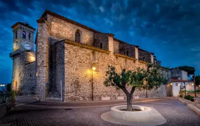 an old stone building with a clock tower at night at Mini Studio - Le Chabaud - Cannes centre in Cannes