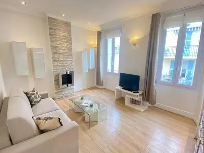 a living room with a couch and a tv at Le Chabaud - Cannes centre in Cannes