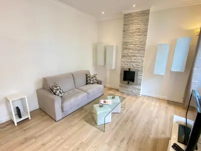 a living room with a couch and a tv at Le Chabaud - Cannes centre in Cannes