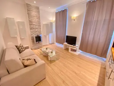 a living room with a couch and a tv at Le Chabaud - Cannes centre in Cannes