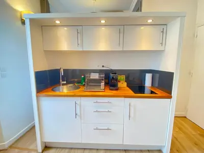 a small kitchen with white cabinets and a sink at Le Chabaud - Cannes centre in Cannes
