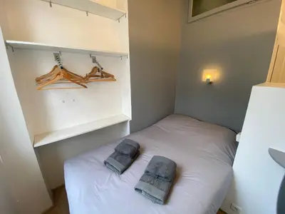 a small bedroom with a white bed with towels on it at Le Chabaud - Cannes centre in Cannes