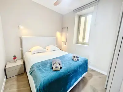 a bedroom with a bed with a blue blanket at Cannes Vidal Rue Antibes SNCF station 2 mn 1 BR new 2024 quiet building hyper center by Olam Properties in Cannes