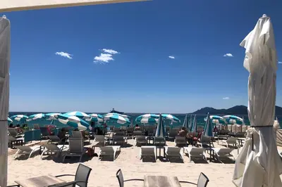 a group of chairs and umbrellas on a beach at Cannes Vidal Rue Antibes SNCF station 2 mn 1 BR new 2024 quiet building hyper center by Olam Properties in Cannes