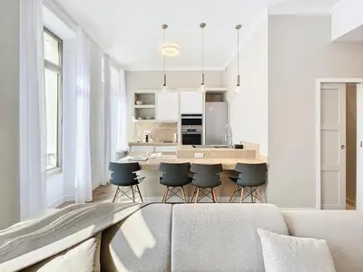 a living room with a couch and a kitchen at Cannes Vidal Rue Antibes SNCF station 2 mn 1 BR new 2024 quiet building hyper center by Olam Properties in Cannes