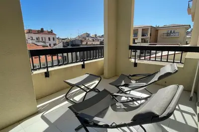 two chairs on a balcony with a view of a city at Stunning 1 BR 3 pers Résidence Cannes Suquet Vieux Port Croisette 1 mn by Olam Properties in Cannes