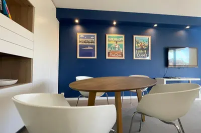a dining room with a table and white chairs at Stunning 1 BR 3 pers Résidence Cannes Suquet Vieux Port Croisette 1 mn by Olam Properties in Cannes