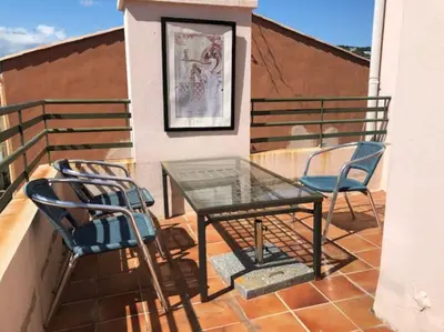 a glass table and two chairs on a balcony at 2 pièces 2 terrasses 100 m Croisette très clair. in Cannes