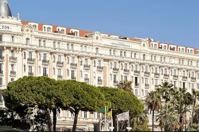 a large white building with trees in front of it at 2 pièces 2 terrasses 100 m Croisette très clair. in Cannes