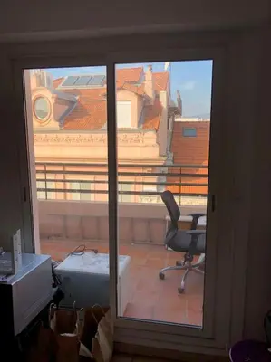 a room with a window with a desk and a chair at 2 pièces 2 terrasses 100 m Croisette très clair. in Cannes
