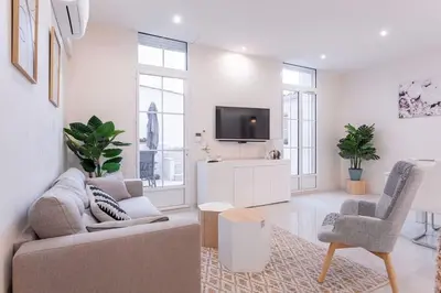 a living room with a couch and a tv at Luxury Apt With Large Terrace On Famous Rue D'antibes! - Pasteur Apt by Halldis in Cannes