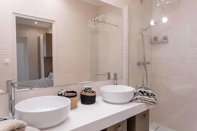 a bathroom with two sinks and a mirror at Luxury Apt With Large Terrace On Famous Rue D'antibes! - Pasteur Apt by Halldis in Cannes