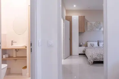a white room with a bed and a bathroom at Luxury Apt With Large Terrace On Famous Rue D'antibes! - Pasteur Apt by Halldis in Cannes