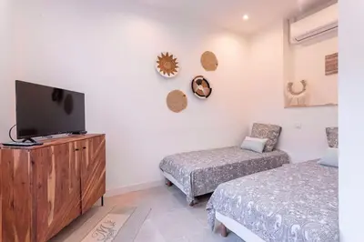 a bedroom with two beds and a flat screen tv at Luxury Apt With Large Terrace On Famous Rue D'antibes! - Pasteur Apt by Halldis in Cannes
