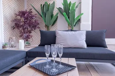 a living room with two wine glasses on a table at Luxury Apt With Large Terrace On Famous Rue D'antibes! - Pasteur Apt by Halldis in Cannes