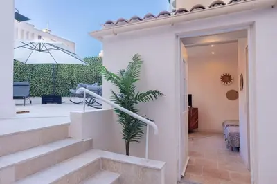a white house with stairs and an umbrella at Luxury Apt With Large Terrace On Famous Rue D'antibes! - Pasteur Apt by Halldis in Cannes