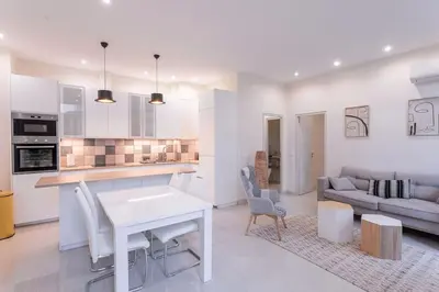 a kitchen and living room with a table and a couch at Luxury Apt With Large Terrace On Famous Rue D'antibes! - Pasteur Apt by Halldis in Cannes