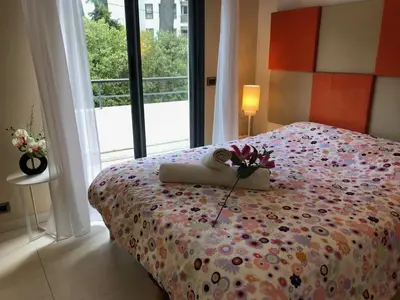 a bedroom with a bed with flowers on it at Appartement montfleury, 2 terrasses, 2 chambres , 2 sdb , pkg privé piscine, 15 min walk to Croisette beach and Palais des festivals in Cannes