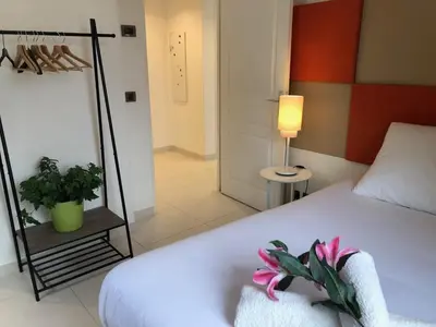 a bedroom with a bed and a lamp and a plant at Appartement montfleury, 2 terrasses, 2 chambres , 2 sdb , pkg privé piscine, 15 min walk to Croisette beach and Palais des festivals in Cannes