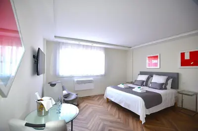 a bedroom with a bed and a table and a window at Studio Cannes Grand Hôtel Eider in Cannes
