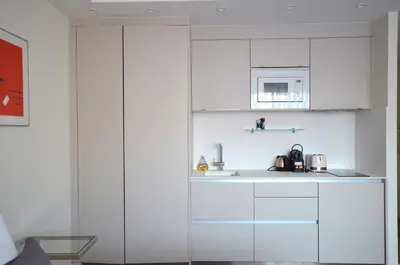 a kitchen with white cabinets and a microwave at Studio Cannes Grand Hôtel Eider in Cannes