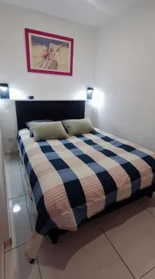 a bedroom with a bed with a blue and white blanket at 2 pièces avec terrasse -Calme-Sans vis à vis-garage-centre de Cannes in Cannes