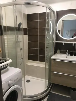 a bathroom with a shower and a sink and a washing machine at 2 pièces avec terrasse -Calme-Sans vis à vis-garage-centre de Cannes in Cannes