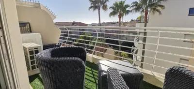 a balcony with chairs and a view of palm trees at Cannes Pointe Croisette studio plage 2 min à Pieds in Cannes