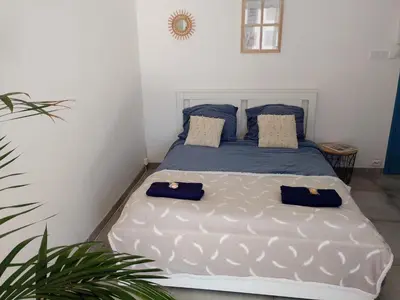 a bedroom with a large bed with blue pillows at Cannes Pointe Croisette studio plage 2 min à Pieds in Cannes