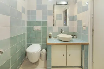 a bathroom with a sink and a toilet and a mirror at Palais Miramar - Suite Blue Room - Vue Mer -Croisette Emplacement Unique - 20M Plage - WIFI - Clim in Cannes