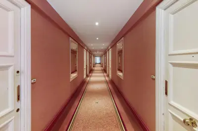 a hallway with orange walls and a long hallway with a ceiling at Palais Miramar - Suite Blue Room - Vue Mer -Croisette Emplacement Unique - 20M Plage - WIFI - Clim in Cannes