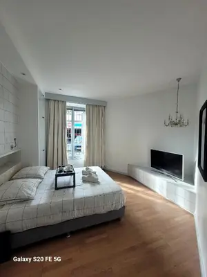 a white bedroom with a bed and a tv at Appartement Cannes Centre - Palais du Festival in Cannes