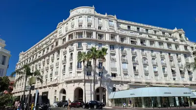 a large white building with palm trees in front of it at Palais Miramar - Cannes Croisette - Across the Beach - Next to Carlton Hotel in Cannes