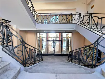 a staircase with wrought iron railings in a building at Palais Miramar - Cannes Croisette - Across the Beach - Next to Carlton Hotel in Cannes