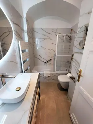a white bathroom with a sink and a toilet at Palais Miramar - Cannes Croisette - Across the Beach - Next to Carlton Hotel in Cannes