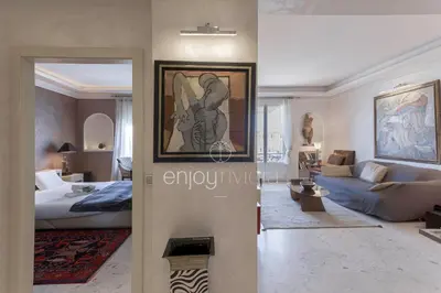 a bedroom with a bed and a living room at Palais Miramar Suite Art Modern - Derniere étages Vue Mer - 75m de confort - En Face des Plages -WIFI - Clim in Cannes