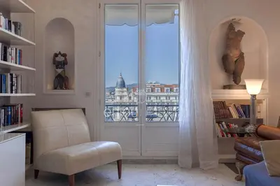 a living room with a window with a view of the city at Palais Miramar Suite Art Modern - Derniere étages Vue Mer - 75m de confort - En Face des Plages -WIFI - Clim in Cannes