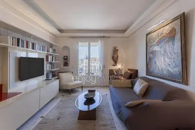 a living room with a couch and a tv at Palais Miramar Suite Art Modern - Derniere étages Vue Mer - 75m de confort - En Face des Plages -WIFI - Clim in Cannes