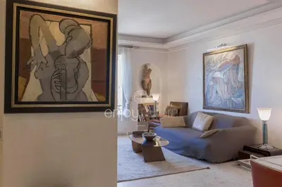 a living room with a couch and a painting on the wall at Palais Miramar Suite Art Modern - Derniere étages Vue Mer - 75m de confort - En Face des Plages -WIFI - Clim in Cannes