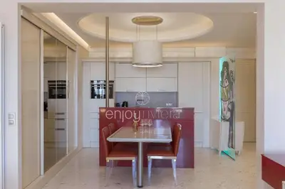 a dining room with a table and chairs at Palais Miramar Suite Art Modern - Derniere étages Vue Mer - 75m de confort - En Face des Plages -WIFI - Clim in Cannes