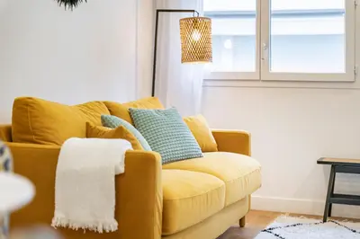 a yellow couch in a living room with a window at Elégant - Hypercentre - Croisette - Palais - AK in Cannes