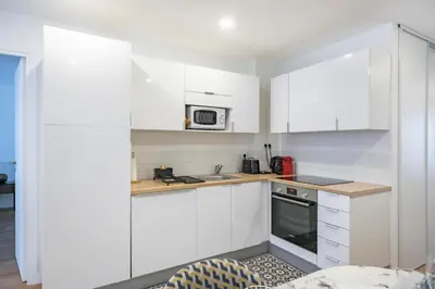a white kitchen with white cabinets and a microwave at Elégant - Hypercentre - Croisette - Palais - AK in Cannes