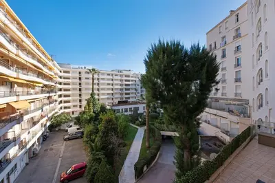 an apartment complex with a courtyard with trees and buildings at Palais Miramar - Suite & B31 - Croisette Emplacement Unique - 20M Plage - WIFI - Clim in Cannes