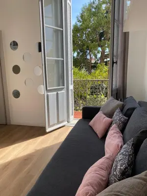 a living room with a couch in front of a door at Joli appartement à 5 minutes du palais et plages in Cannes