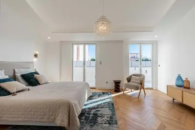 a white bedroom with a large bed and a chandelier at Sumptuous renovated Penthouse - Gray d'Albion-Croi in Cannes