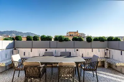 a patio with a table and chairs on a roof at Sumptuous renovated Penthouse - Gray d'Albion-Croi in Cannes