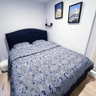 a bedroom with a bed with a blue and white comforter at CROISETTE VUE MER LATERALE in Cannes