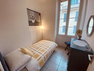 a bedroom with a bed and a desk and a window at 2 bedroom apartment in the heart of Cannes air conditioning easy walk to the Palais des Festivals - 2015 in Cannes